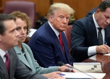 Trump in court, flanked by his lawyers. Photo credit: Getty Images