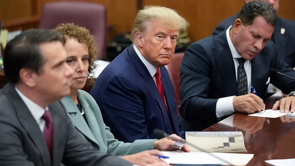 Trump in court, flanked by his lawyers. Photo credit: Getty Images